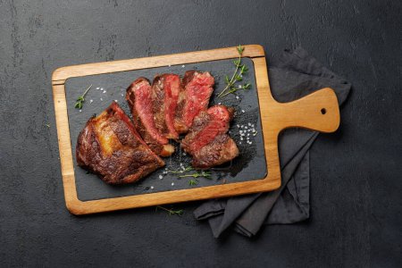 Téléchargez les photos : Délicieusement juteux steak côtelé de bœuf tranché, parfaitement cuit et prêt à être savouré. Pose plate - en image libre de droit