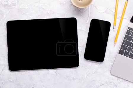 Photo for Blank black screen smartphone and tablet on a desk, perfect for your design mockup - Royalty Free Image