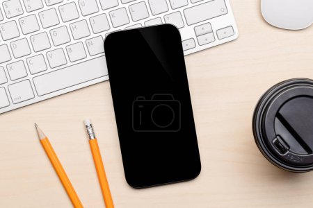 Photo for Blank black screen smartphone on a desk, perfect for your design mockup - Royalty Free Image