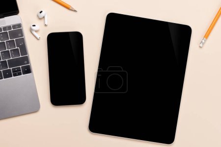 Téléchargez les photos : Smartphone écran noir vierge et tablette sur un bureau, parfait pour votre maquette design - en image libre de droit