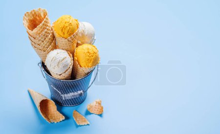 Foto de Helado de limón en deliciosos conos de gofres, una delicia para todos los gustos. Sobre fondo azul con espacio de copia - Imagen libre de derechos