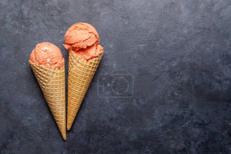 Téléchargez les photos : Saveurs de crème glacée dans de délicieux cônes de gaufres, un régal pour tous les papilles. Sur fond de pierre avec espace de copie. Pose plate - en image libre de droit