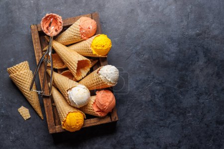 Photo for Assorted ice cream flavours in delightful waffle cones, a treat for every taste bud. Over stone background with copy space. Flat lay - Royalty Free Image