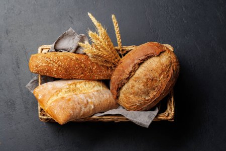 Téléchargez les photos : Variétés de pain variées dans un charmant panier, prêt à être dégusté. Pose plate - en image libre de droit