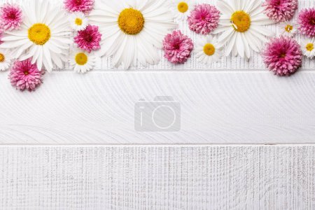 Téléchargez les photos : Des fleurs de jardin assorties fleurissent sur un fond en bois avec de l'espace pour le texte. Pose plate - en image libre de droit