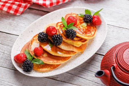 Photo for Tasty homemade pancakes with berries and honey syrup - Royalty Free Image