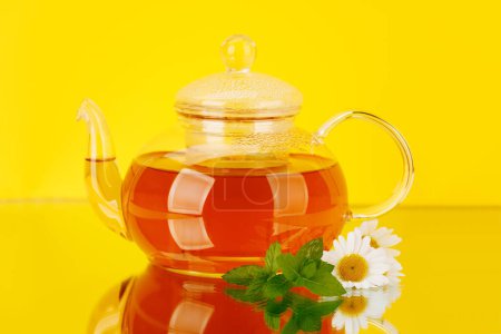 Foto de Calmante mezcla de té de hierbas con menta y manzanilla. Sobre fondo amarillo - Imagen libre de derechos