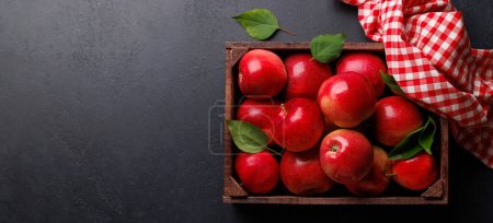 Photo for Wooden box with fresh red apples on stone table. Flat lay with copy space - Royalty Free Image