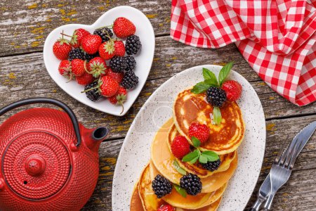 Photo for Tasty homemade pancakes with berries and honey syrup. Flat layspace - Royalty Free Image
