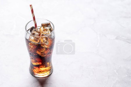 Erfrischendes Glas Cola mit Eis. Auf Steintisch mit Kopierraum