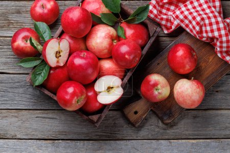 Foto de Caja de madera con manzanas rojas frescas sobre mesa de madera. Puesta plana - Imagen libre de derechos