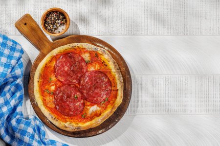 Foto de Pizza de pepperoni casera, rematada con pasta de tomate fresca y queso mozzarella. Piso con espacio de copia - Imagen libre de derechos