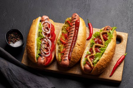 Téléchargez les photos : Divers hot-dogs. Hotdogs faits maison sur planche à découper - en image libre de droit