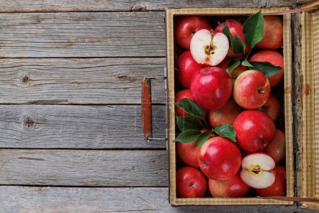 Foto de Caja de madera con manzanas rojas frescas sobre mesa de madera. Piso con espacio de copia - Imagen libre de derechos