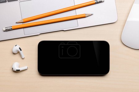 Téléchargez les photos : Smartphone écran noir vierge sur un bureau, parfait pour votre maquette design - en image libre de droit