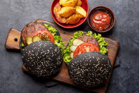 Téléchargez les photos : Burgers de bœuf maison avec petits pains noirs. Pose plate - en image libre de droit