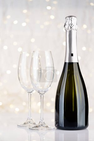 Photo for Champagne bottle and glasses in front of Christmas lights bokeh - Royalty Free Image