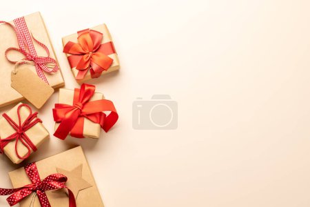 Téléchargez les photos : Coffrets cadeaux de Noël sur fond beige et espace pour le texte de salutations. Pose plate - en image libre de droit