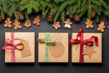 Photo for Christmas fir tree branch with cookies and gift boxes. Flat lay - Royalty Free Image