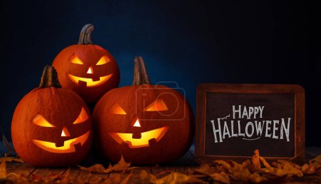 Foto de Calabazas de Halloween en mesa de madera con saludos - Imagen libre de derechos
