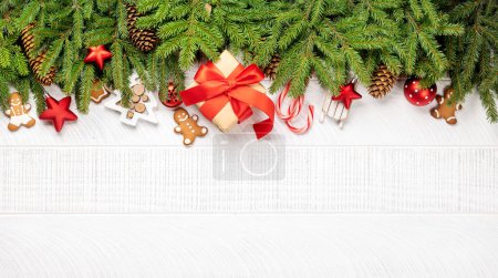 Photo for Christmas fir tree branch with decor, cookies, gift box and space for greetings text. Flat lay - Royalty Free Image
