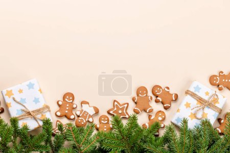 Photo for Xmas fir tree branch, Christmas gift boxes, gingerbread cookies and space for greetings text. Flat lay - Royalty Free Image