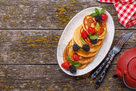 Photo for Tasty homemade pancakes with berries and honey syrup. Flat lay with copy space - Royalty Free Image
