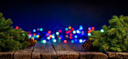 Foto de Ramas de árbol de Navidad con piñas y guirnalda bokeh. Con espacio de copia - Imagen libre de derechos