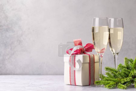 Photo for Two champagne glasses and gift box. Christmas greeting card template with copy space - Royalty Free Image