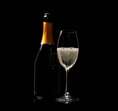 Téléchargez les photos : Verre à champagne et bouteille sur fond noir - en image libre de droit
