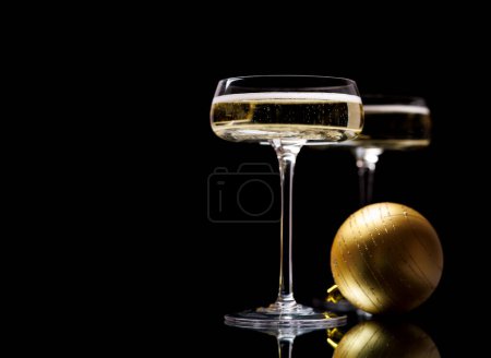 Photo for Two champagne glasses and Christmas bauble on a black background - Royalty Free Image