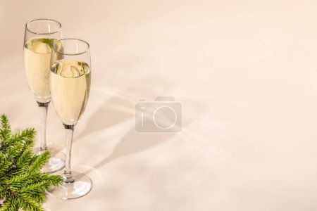 Foto de Dos copas de champán sobre fondo beige con espacio para copiar. Tarjeta de felicitación de Navidad plantilla - Imagen libre de derechos