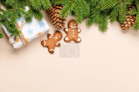 Téléchargez les photos : Branche de sapin de Noël, boîte cadeau de Noël, biscuits au pain d'épice et espace pour le texte de salutations. Pose plate - en image libre de droit
