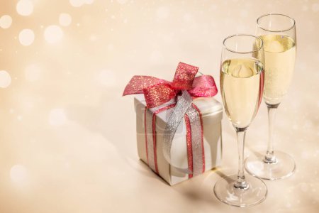 Téléchargez les photos : Deux verres à champagne et une boîte cadeau. Modèle de carte de voeux de Noël avec espace de copie - en image libre de droit