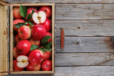 Photo for Wooden box with fresh red apples on wood table. Flat lay with copy space - Royalty Free Image