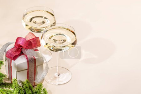 Photo for Two champagne glasses and gift box. Christmas greeting card template with copy space - Royalty Free Image