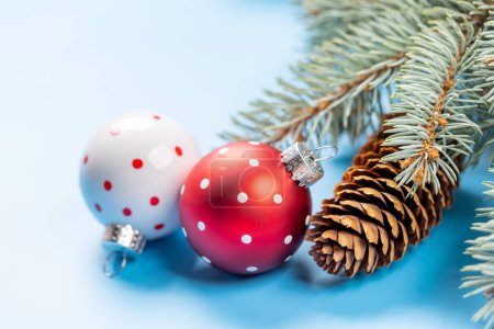 Photo for Christmas fir tree branch and bauble decor over blue background with space for greetings text - Royalty Free Image
