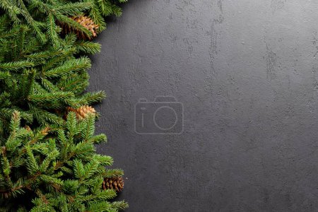 Photo for Christmas fir tree branch frame over stone with space for greetings text. Flat lay - Royalty Free Image