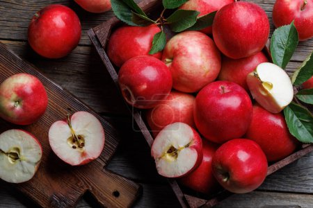 Foto de Caja de madera con manzanas rojas frescas sobre mesa de madera. Puesta plana - Imagen libre de derechos