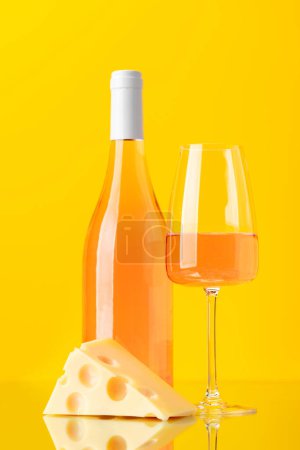 Photo for Aromatic rose wine poured into a glass, accompanied by a tempting piece of cheese - Royalty Free Image