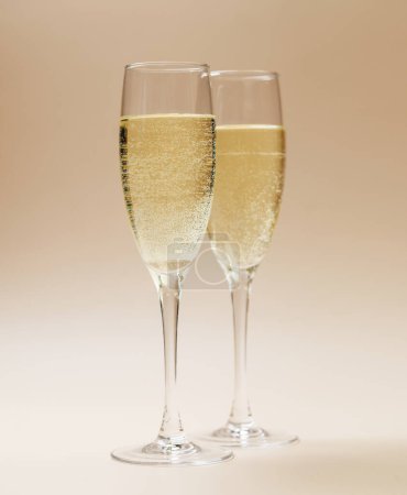 Foto de Dos copas de champán sobre fondo beige - Imagen libre de derechos