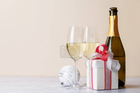 Téléchargez les photos : Deux verres à champagne et une boîte cadeau. Modèle de carte de voeux de Noël avec espace de copie - en image libre de droit