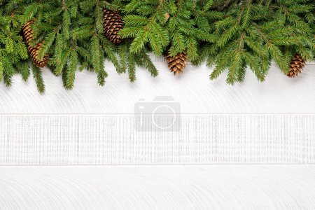 Téléchargez les photos : Armature de branches de sapin de Noël sur bois blanc avec espace pour salutations texte. Pose plate - en image libre de droit