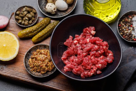 Téléchargez les photos : Cuisson tartare de bœuf salé avec cornichons marinés et pain grillé brun - en image libre de droit