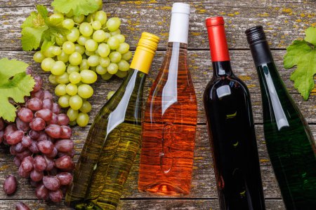 Photo for Wine bottles and grape on wooden table. Flat lay - Royalty Free Image