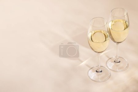 Téléchargez les photos : Deux verres à champagne sur fond beige avec espace de copie - en image libre de droit