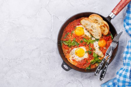 Téléchargez les photos : Délicieux petit déjeuner shakshuka dans une casserole. Pose plate avec espace de copie - en image libre de droit