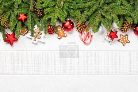Téléchargez les photos : Branche de sapin de Noël avec décor, biscuits et espace pour salutations texte. Pose plate - en image libre de droit