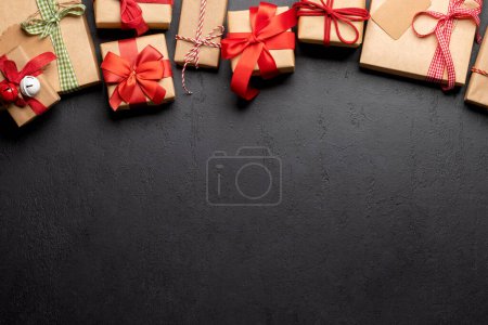 Photo for Christmas gift boxes over stone backdrop and space for greetings text. Flat lay - Royalty Free Image