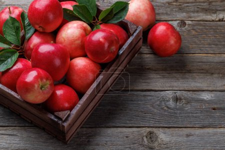 Photo for Wooden box with fresh red apples on wood table. With copy space - Royalty Free Image